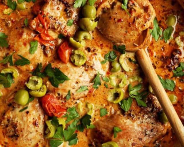 Baked Marry Me Chicken topped with green olives and fresh parsley.