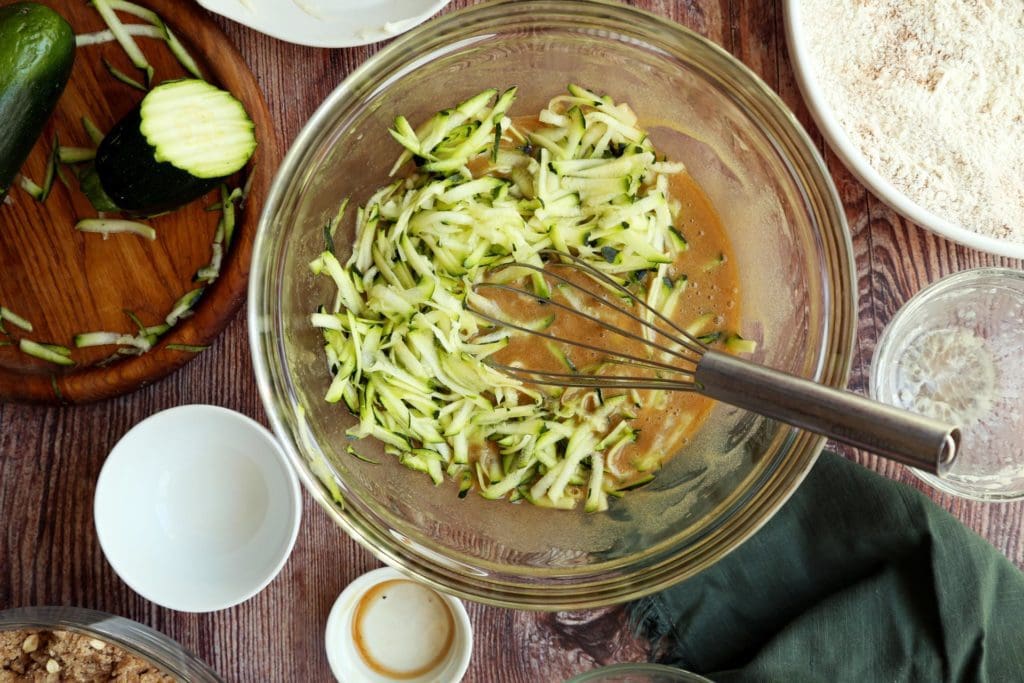 Shredded fresh zucchini in sugar and egg mixture for coffee cake recipe.