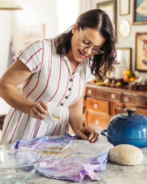 Sprinkling everything bagel seasoning on flour sack towel.