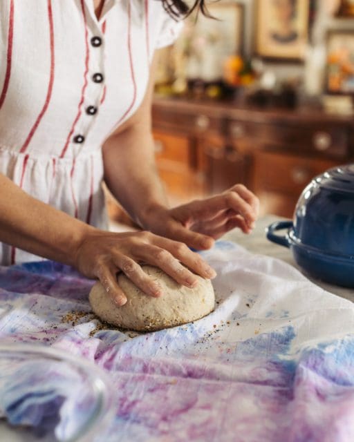 dipping top of bread dough in everything bagel seasoning.