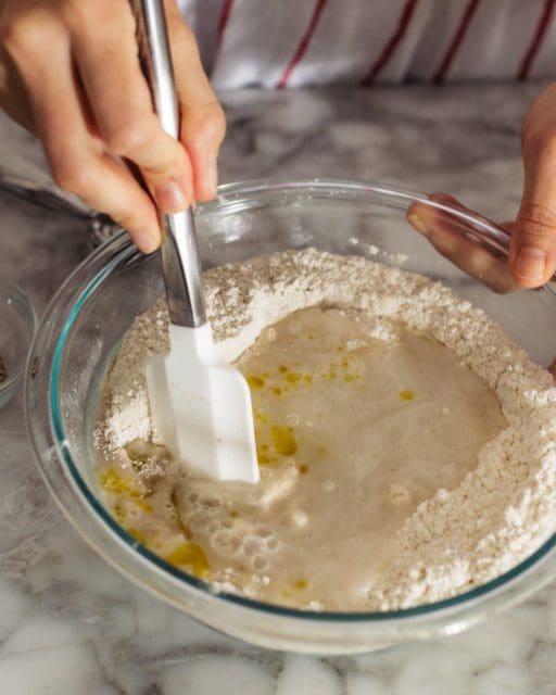 stirring water into dry ingredients for bread.