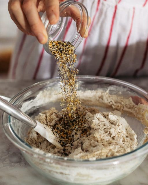 adding everything bagel seasoning to bread dough.