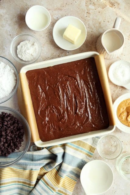 box brownie batter in a parchment lined pan