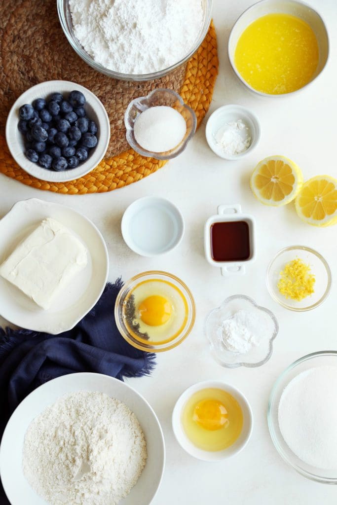 Ingredients for lemon blueberry gooey butter cake measured in small bowls.