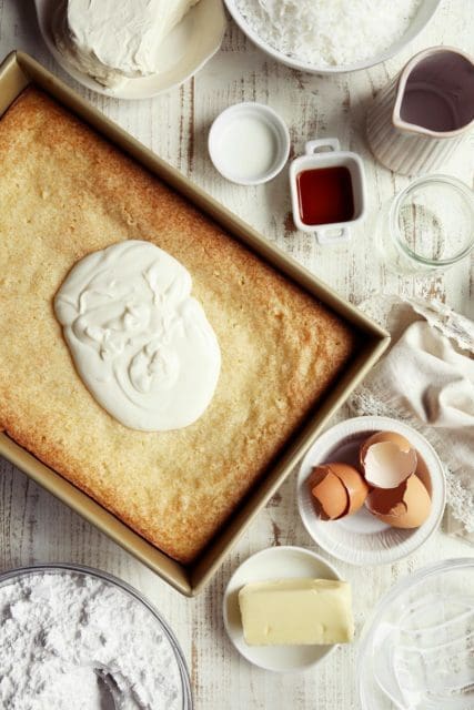 Baked coconut cake with a puddle of sour cream topping on top.