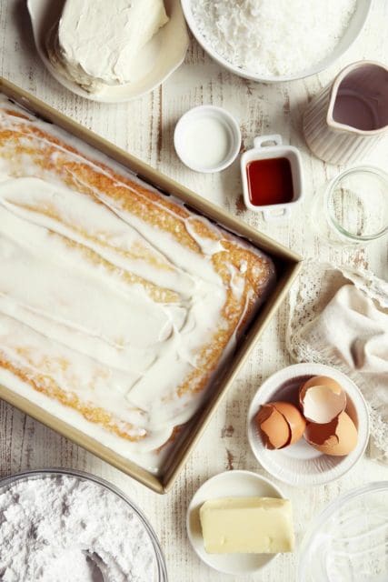 Sour cream topping spread over easy coconut cake.