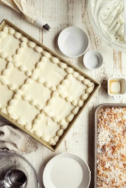 Frosted coconut cake in pan.