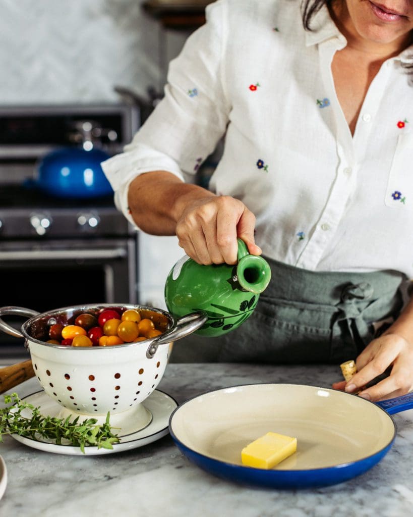 Pouring olive oil in skillet with butter for easy tomato pie recipe.
