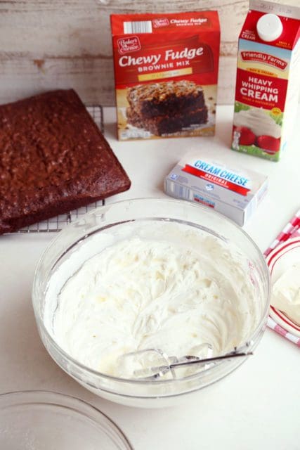 Whipped cream with beaters in a large bowl.