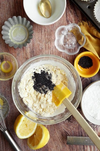 Adding poppy seeds to muffins.