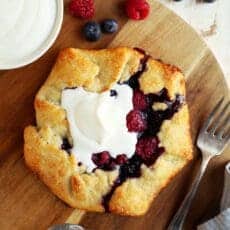 Berry crostata topped with whipped cream with coffee.