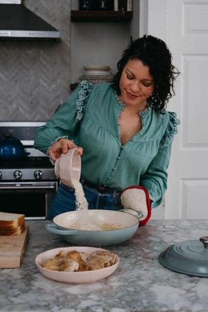 Adding rice to baked nashville hot chicken recipe.
