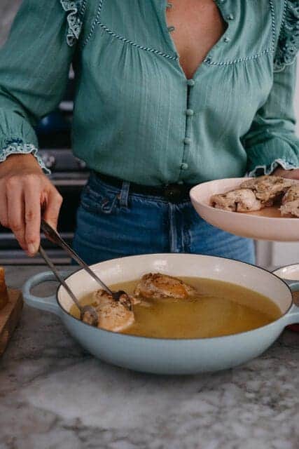 Putting chicken thighs in pan.