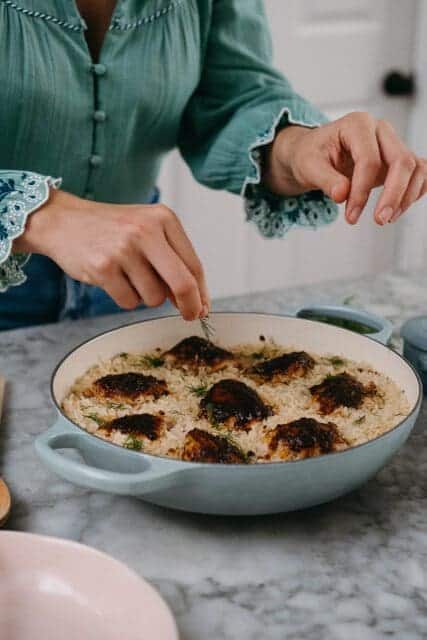 Tearing fresh dill over Nashville hot chicken recipe.