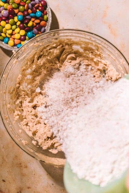 Pouring dry ingredients into creamed butter.
