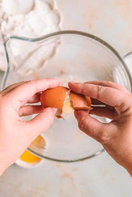 Adding an egg to the yeast mixture for pull apart garlic bread.