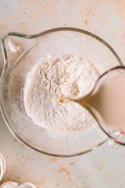 Pouring milk into mixing bowl.