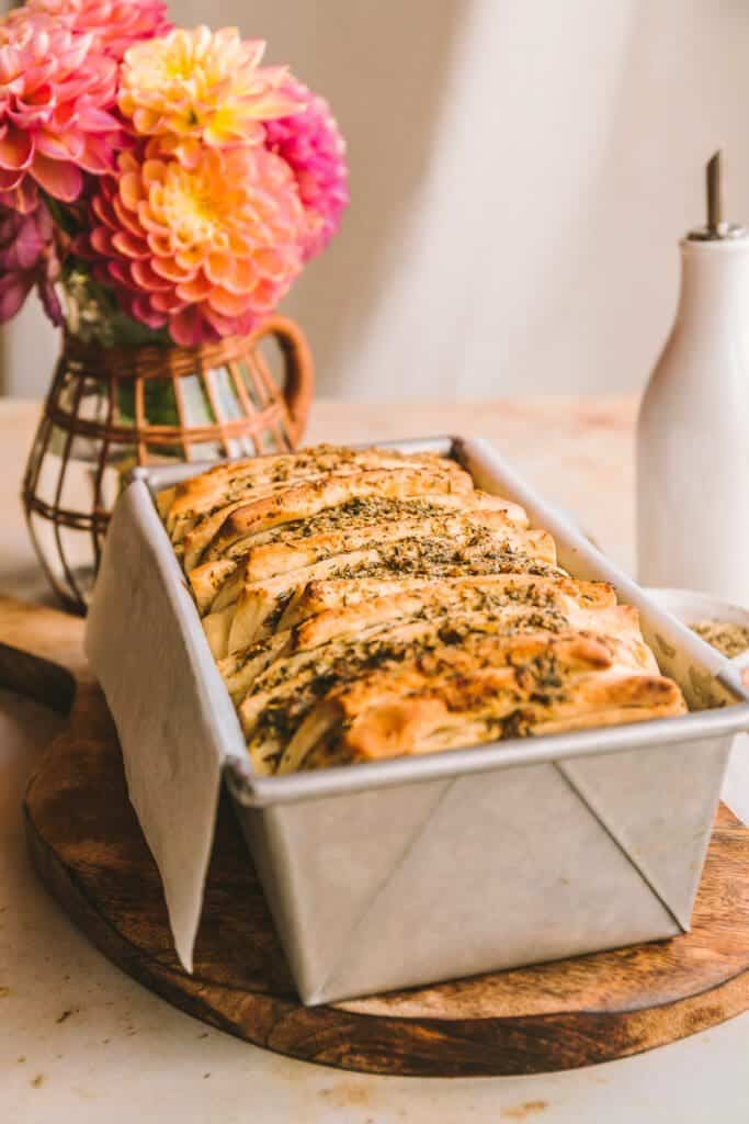 Baked pull apart garlic bread baked in a loaf pan. 