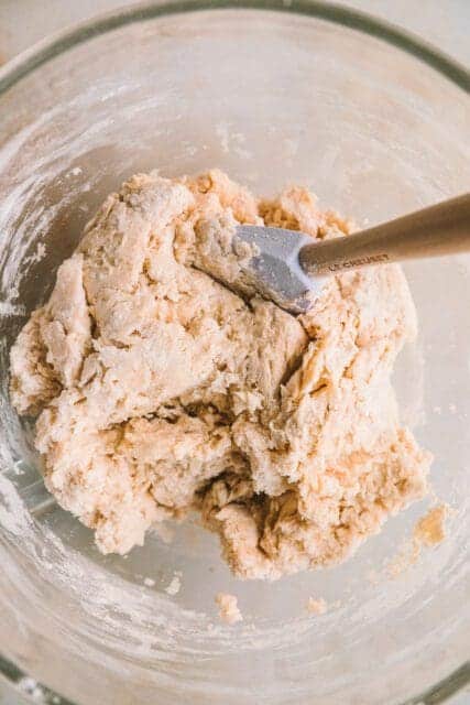 Mixeddough in bowl with spatula.