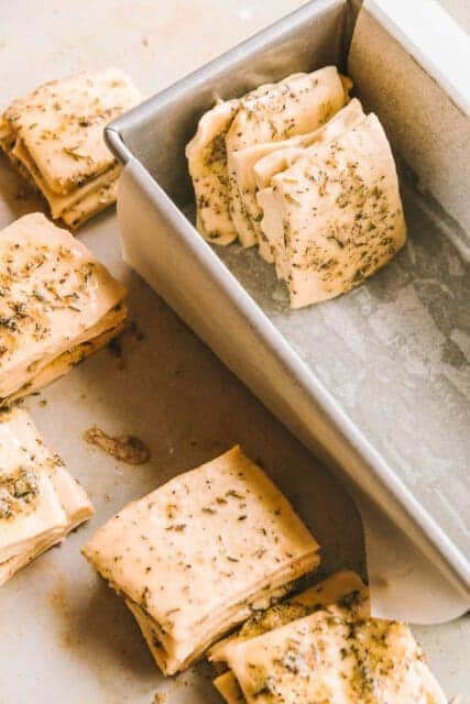 Arranging dough squares in a loaf pan