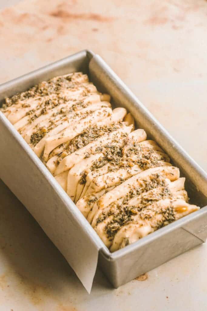 Proofed pull apart garlic bread dough in the pan.