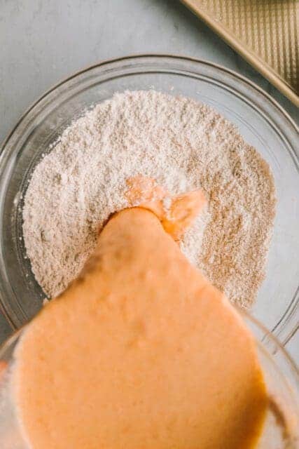 pouring wet ingredients into dry pancake ingredients