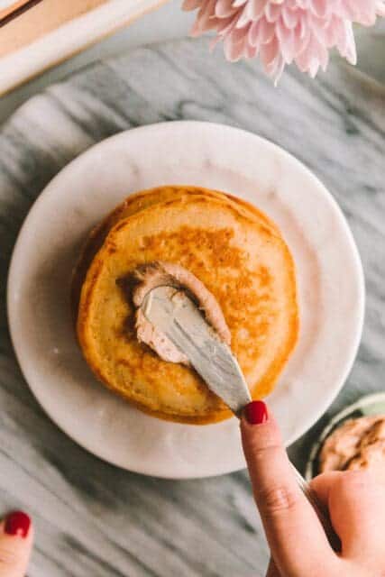spreading spiced butter over stack of pancakes