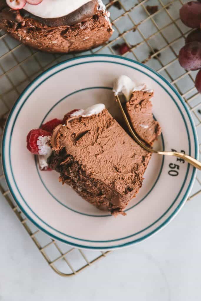 A slice of chocolate basque cheesecake on a small plate with fork.
