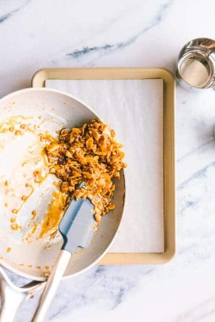 pouring cereal brittle onto a baking sheet.
