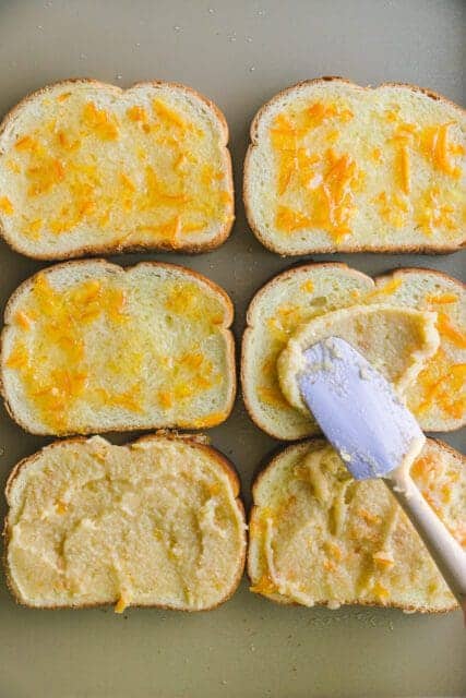 spreading ingredients on toast on a baking sheet for bostock.