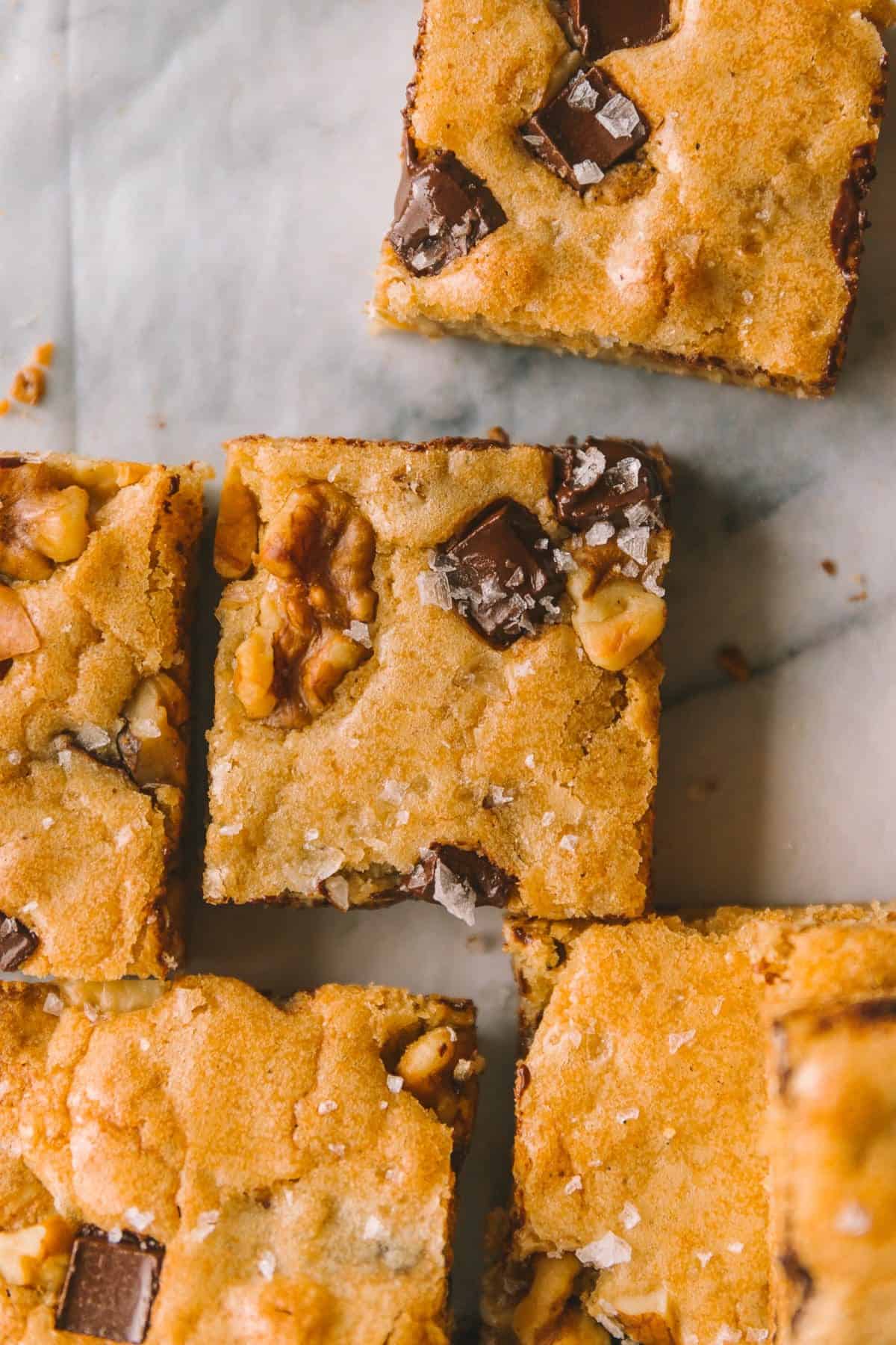 completed recipe close up shot of a blondie so the toasted almonds, chocolate chips, and sea salt can be seen