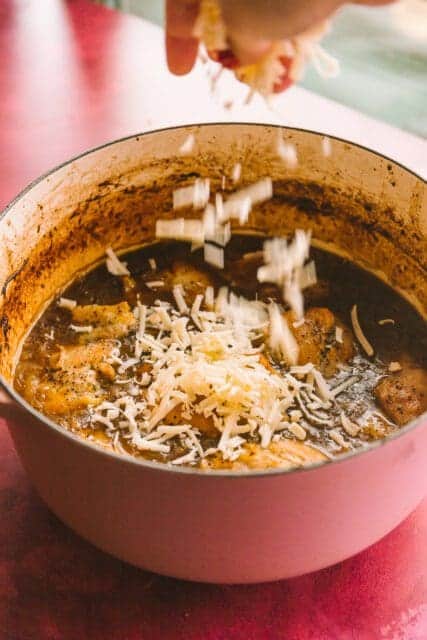 sprinkling gruyere over French onion chicken