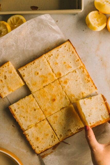 removing a cut square of finished lemon bar recipe