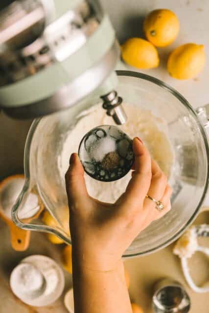 pouring dry ingredients into a bowl for lemon bars recipe