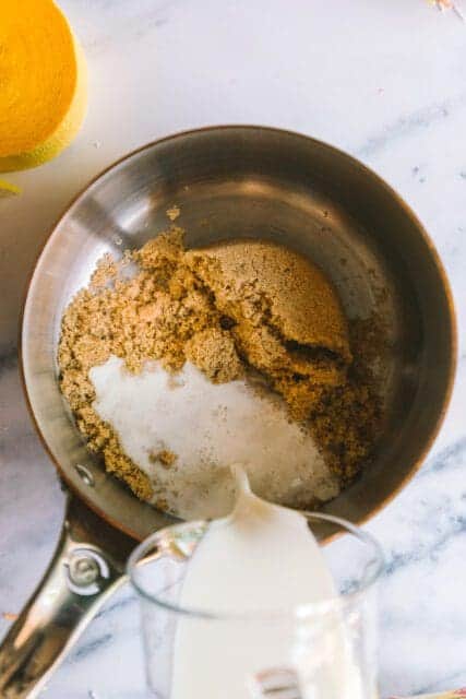 adding brown sugar and milk to a saucepan to make a vintage birthday cake frosting