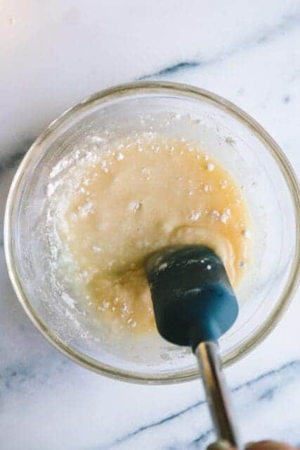 stirring ingredients together in a glass bowl for birthday cake recipes