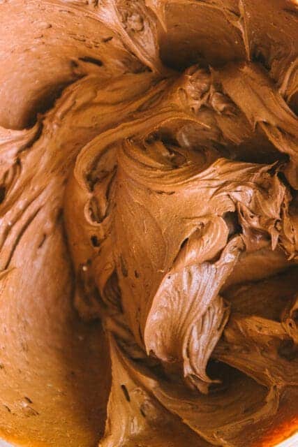 close up shot of chocolate frosting to top a vintage birthday cake
