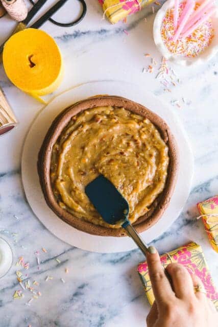 adding filling onto a layer of birthday cake