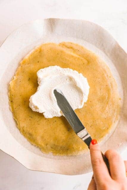 adding whipped cream to layers of crêpes