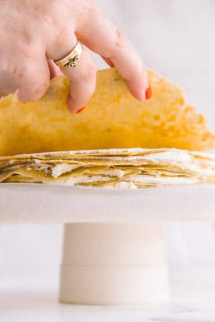 adding a layer of crêpe on top of whipped cream