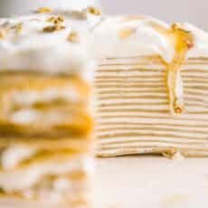 close up view of crepe cake cross section with honey dripping down