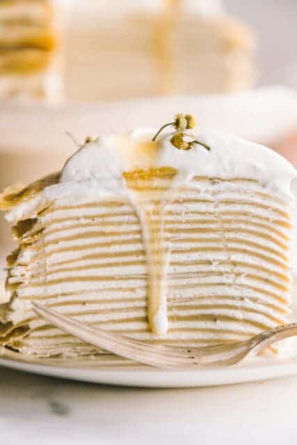 photo of the layers of crêpes and cream with honey dripping down the side