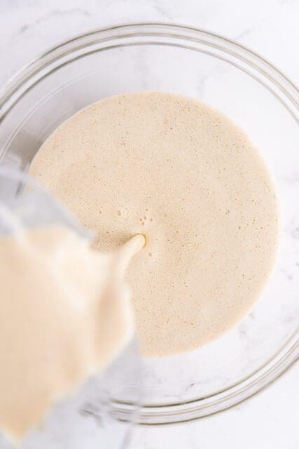 pouring prepared crêpe batter into a bowl to rest