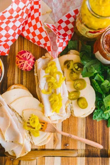 adding banana peppers to the car sandwich