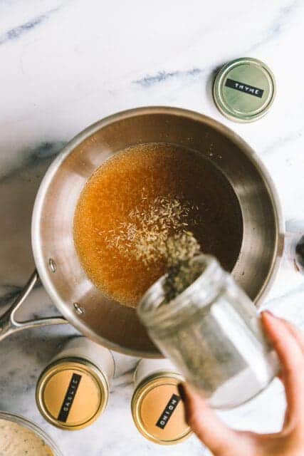 adding ingredients to make an au jus for the French dip sandwich