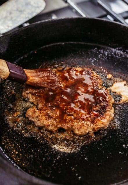 brushing marinade onto smash burgers