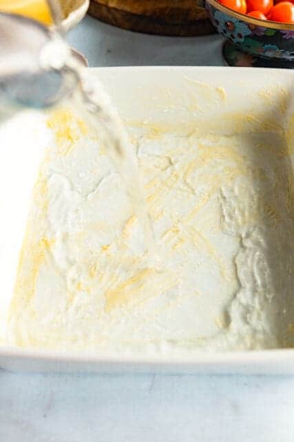 adding ingredients for baked polenta recipe