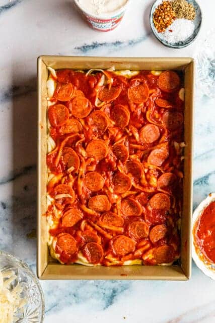 an insane but appropriate amount of pepperoni to top focaccia pizza