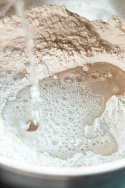 adding warm water to flour to make focaccia