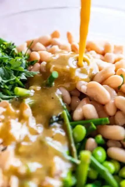 vinaigrette poured over asparagus salad